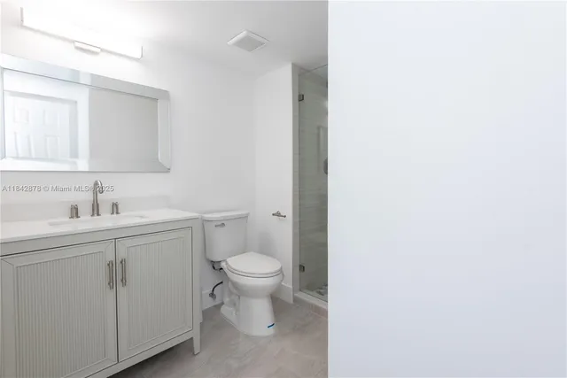 a bathroom with a toilet sink a mirror and vanity