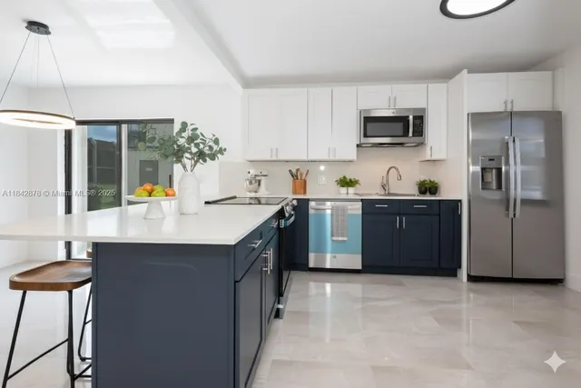 a kitchen with stainless steel appliances a sink stove and refrigerator