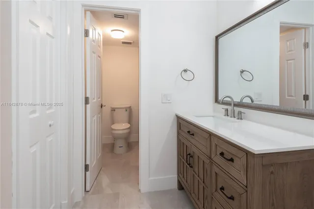 a bathroom with a double vanity sink mirror and toilet
