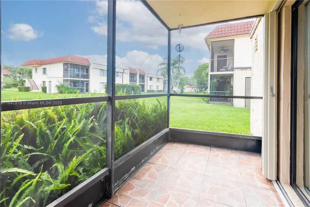 a view of a white house with a big yard and large trees