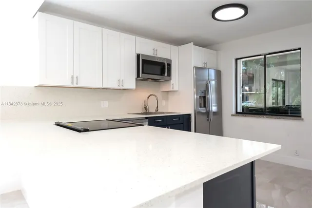 a kitchen with granite countertop a sink a stove and a refrigerator