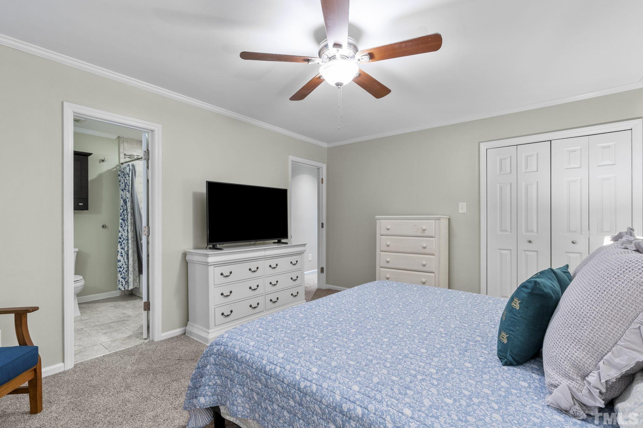 5666 Hamstead Crossing Raleigh, NC 27612 - Photo 9 of 32 a bedroom with a bed and a flat screen tv