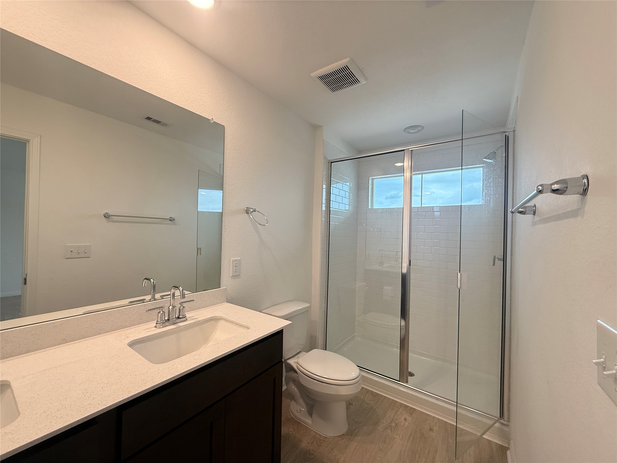 120 Calla Lane Georgetown, TX 78626 - Photo 10 of 19 Bathroom with double vanity, a stall shower, and dark wood-type flooring