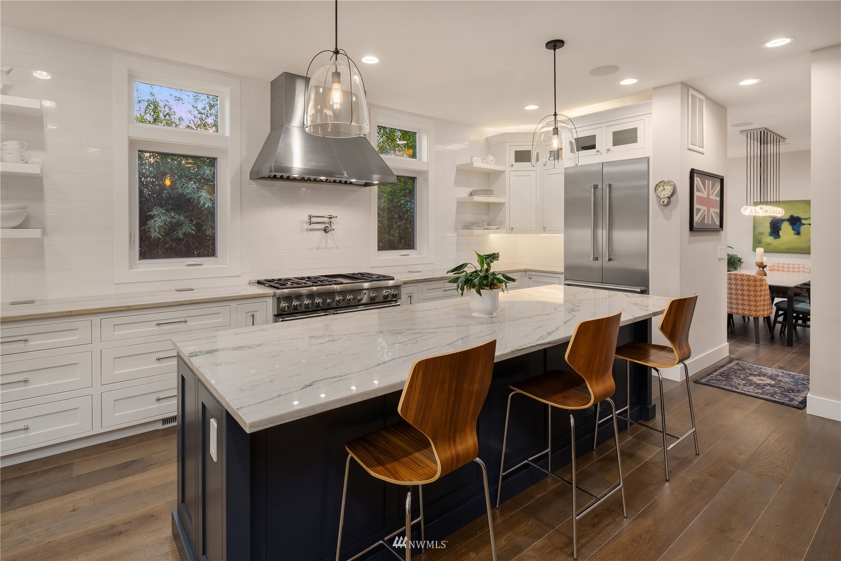 111 North 76th Street Seattle, WA 98103 - Photo 6 of 40 a kitchen with granite countertop a table chairs stove and kitchen island