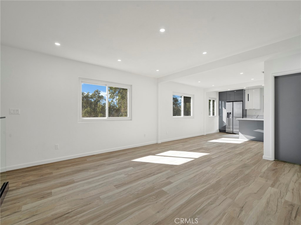 727 Robinson Street Los Angeles, CA 90026 - Photo 9 of 28 a view of empty room with wooden floor and kitchen view
