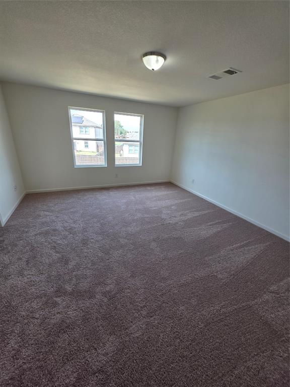 477 Bank Way Crowley, TX 76036 - Photo 10 of 39 Carpeted empty room with baseboards and a textured ceiling