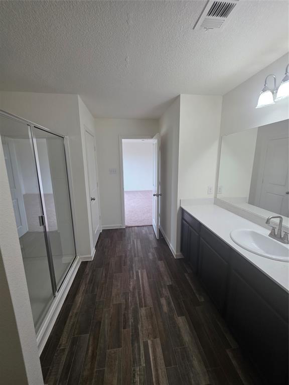 477 Bank Way Crowley, TX 76036 - Photo 14 of 39 Full bathroom with a textured ceiling, wood finished floors, vanity, and a shower stall
