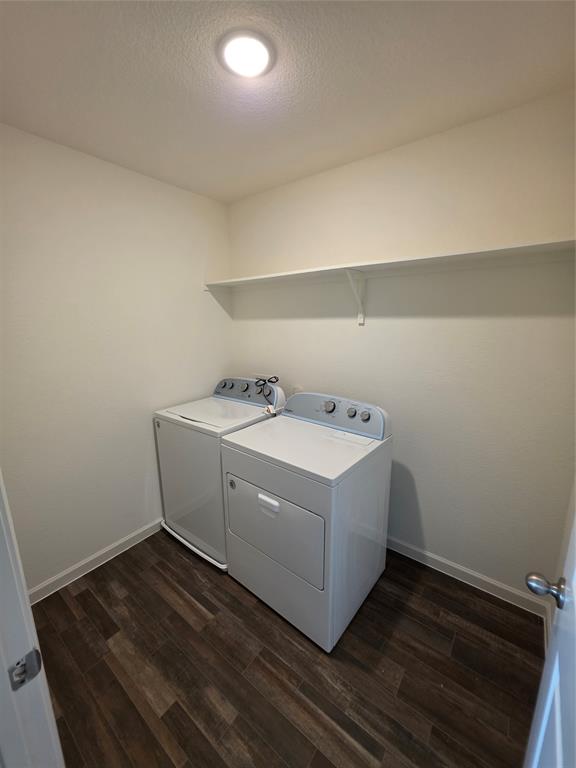 477 Bank Way Crowley, TX 76036 - Photo 18 of 39 Laundry room featuring washing machine and clothes dryer, dark wood-style flooring, and a textured ceiling
