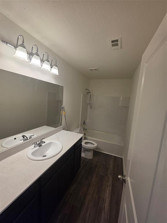 477 Bank Way Crowley, TX 76036 - Photo 25 of 39 Bathroom featuring wood finished floors, vanity, a textured ceiling, and tub / shower combination