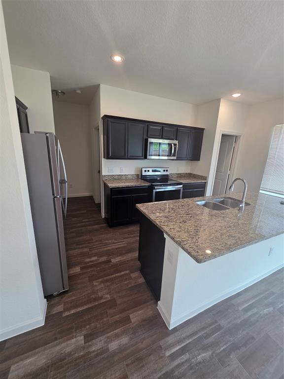 477 Bank Way Crowley, TX 76036 - Photo 29 of 39 Kitchen with refrigerator, electric range, light stone counters, recessed lighting, and dark wood finished floors