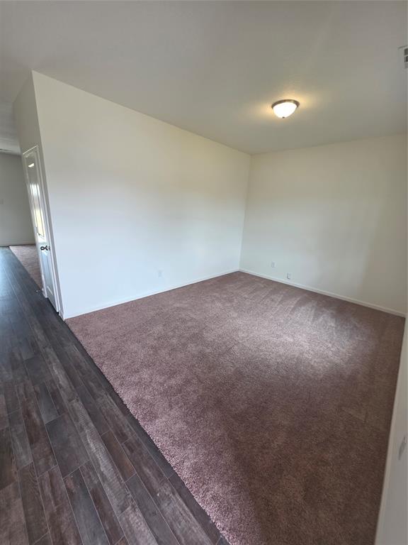 477 Bank Way Crowley, TX 76036 - Photo 4 of 39 Unfurnished room featuring dark wood finished floors and dark carpet