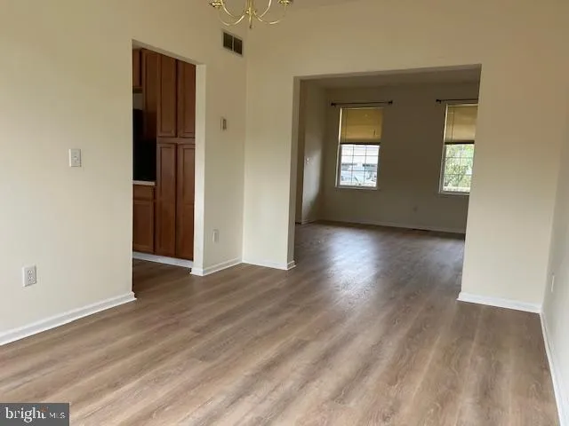 a view of a hallway with wooden floor and a living room