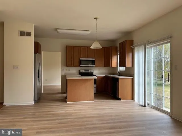 a kitchen with stainless steel appliances granite countertop a refrigerator a sink dishwasher a stove and a refrigerator