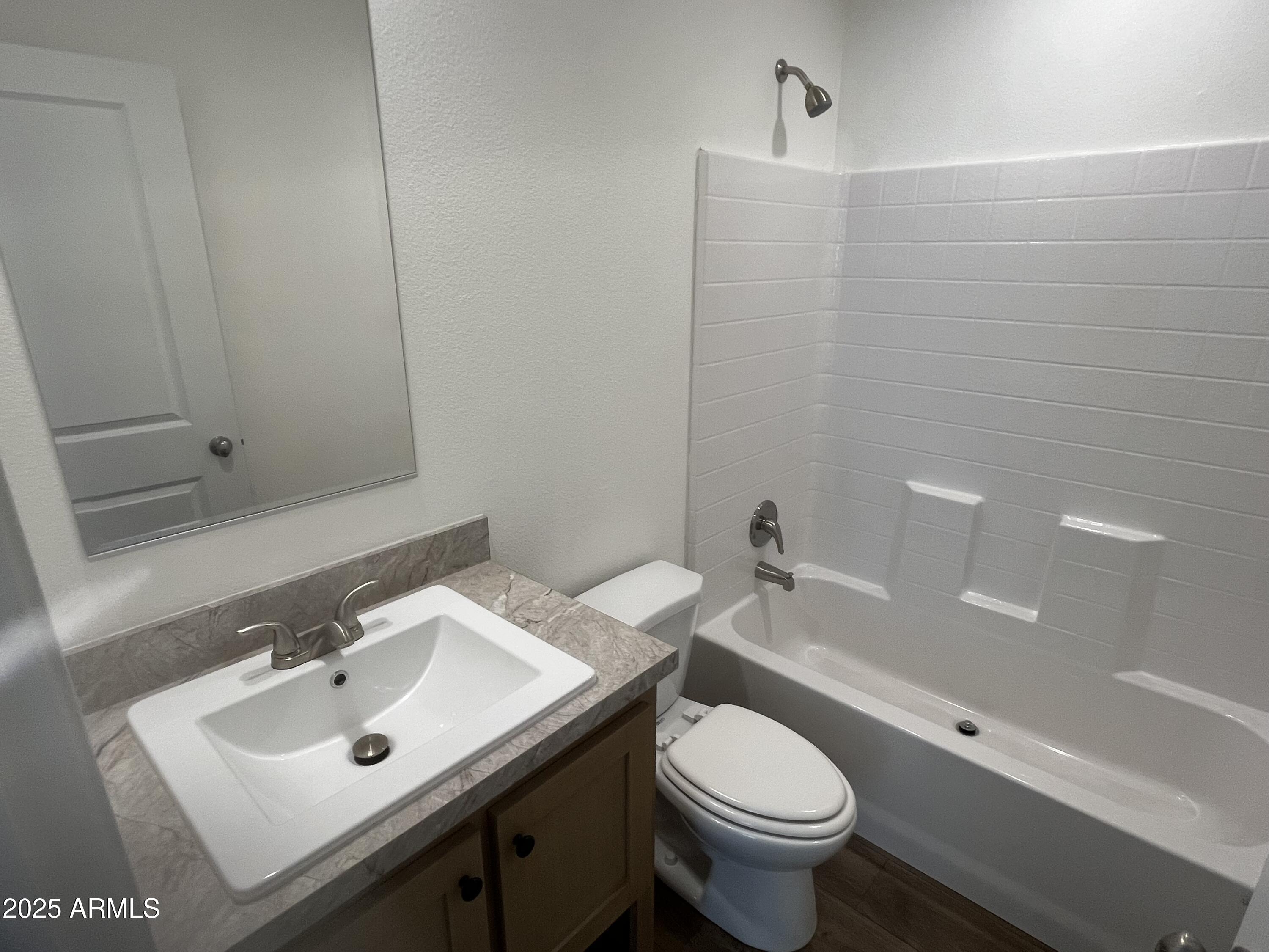 22936 West Forest Pleasant Place, Unit 2 Wittmann, AZ 85361 - Photo 11 of 17 a bathroom with a sink toilet and a mirror