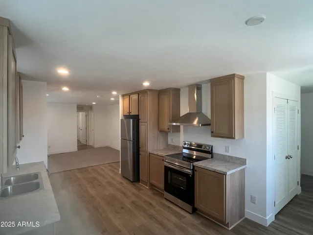 a kitchen with stainless steel appliances granite countertop a refrigerator and a stove