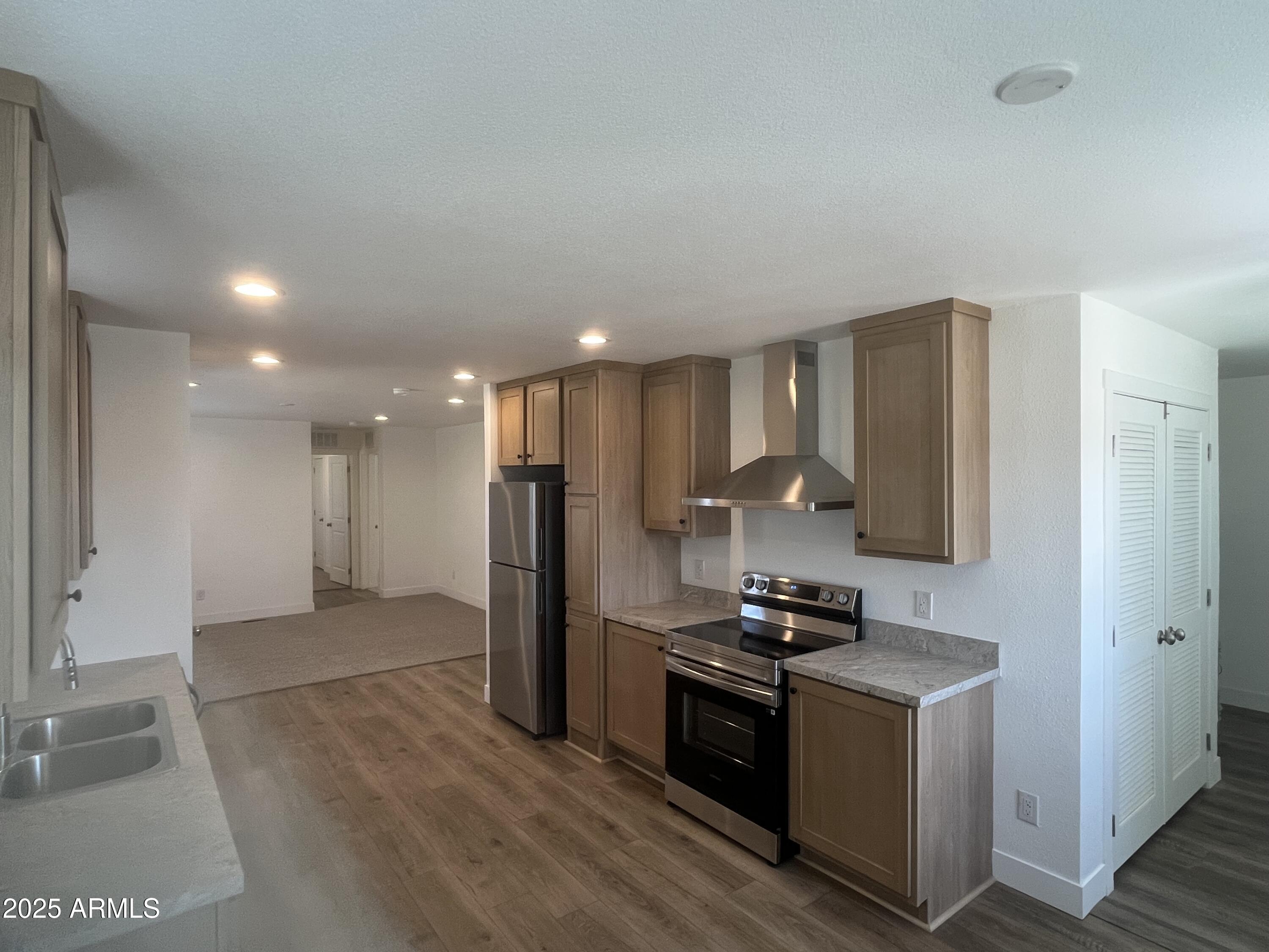 22936 West Forest Pleasant Place, Unit 2 Wittmann, AZ 85361 - Photo 3 of 17 a kitchen with stainless steel appliances granite countertop a refrigerator and a stove