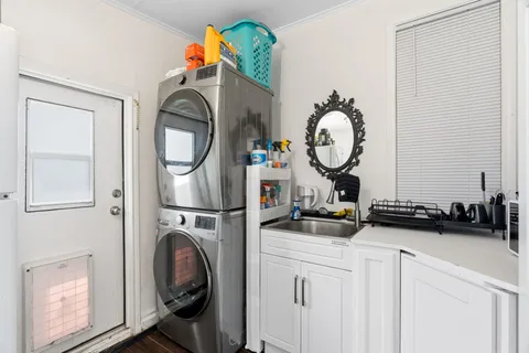 a very nice looking room with kitchen island stainless steel appliances furniture cabinets and wooden floor
