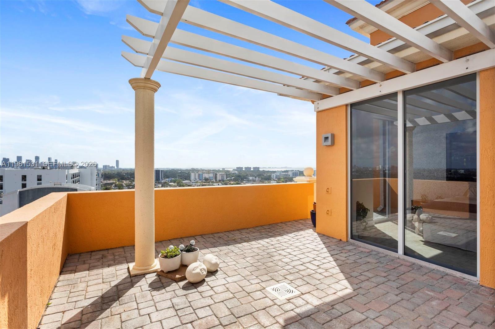 3232 Southwest 22nd Terrace, Unit PH2002 Miami, FL 33145 - Photo 14 of 35 a view of a balcony with a floor to ceiling window and wooden floor