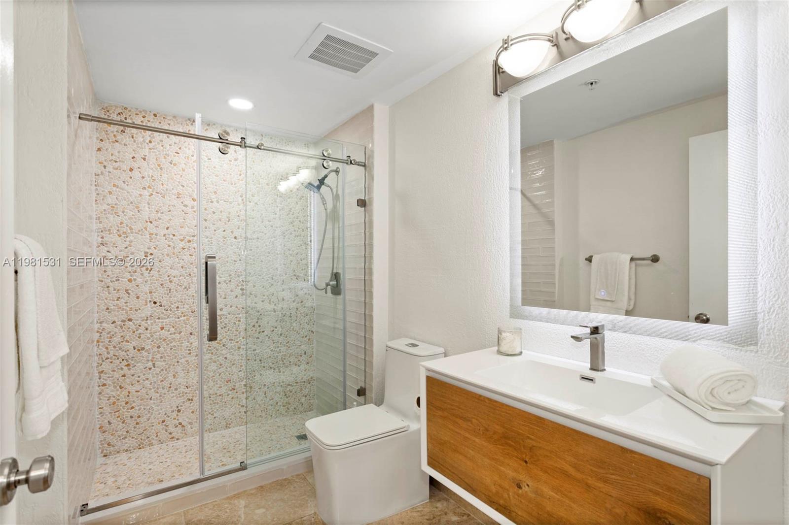 3232 Southwest 22nd Terrace, Unit PH2002 Miami, FL 33145 - Photo 20 of 35 a bathroom with a sink toilet a mirror and shower