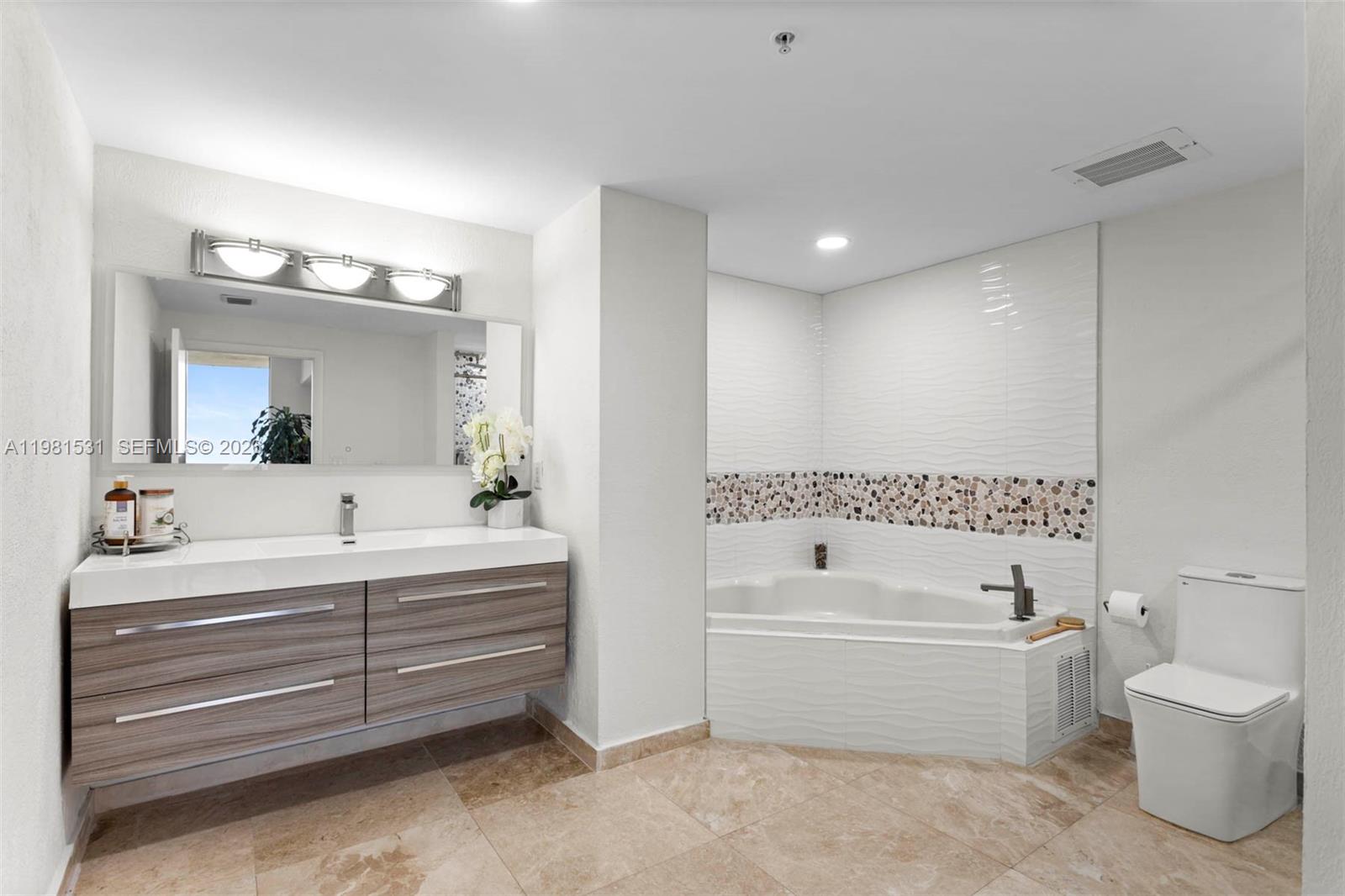 3232 Southwest 22nd Terrace, Unit PH2002 Miami, FL 33145 - Photo 25 of 35 a bathroom with a bathtub a toilet a sink and mirror