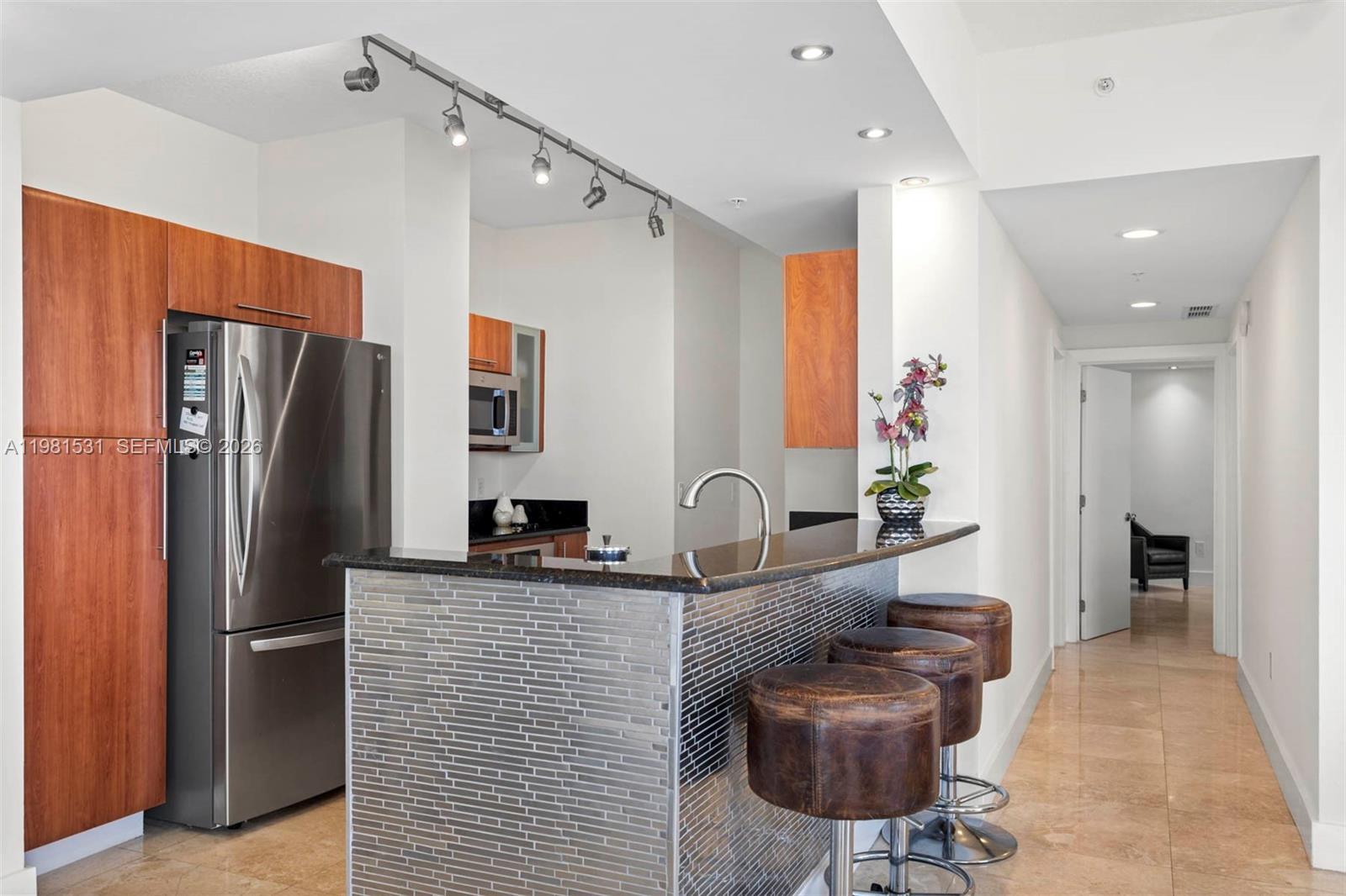 3232 Southwest 22nd Terrace, Unit PH2002 Miami, FL 33145 - Photo 7 of 35 a kitchen with stainless steel appliances granite countertop a refrigerator and a sink