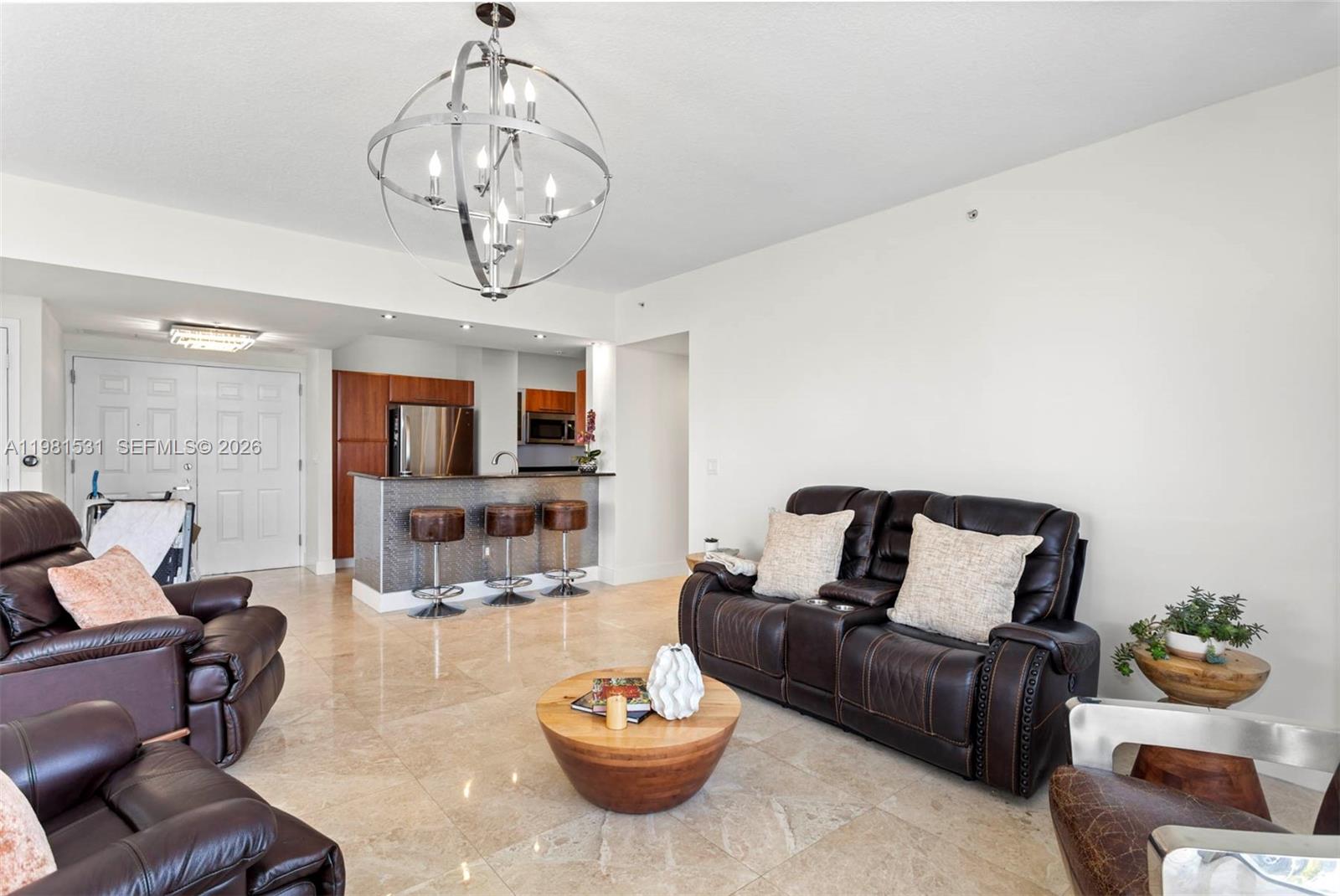 3232 Southwest 22nd Terrace, Unit PH2002 Miami, FL 33145 - Photo 8 of 35 a living room with furniture and a chandelier