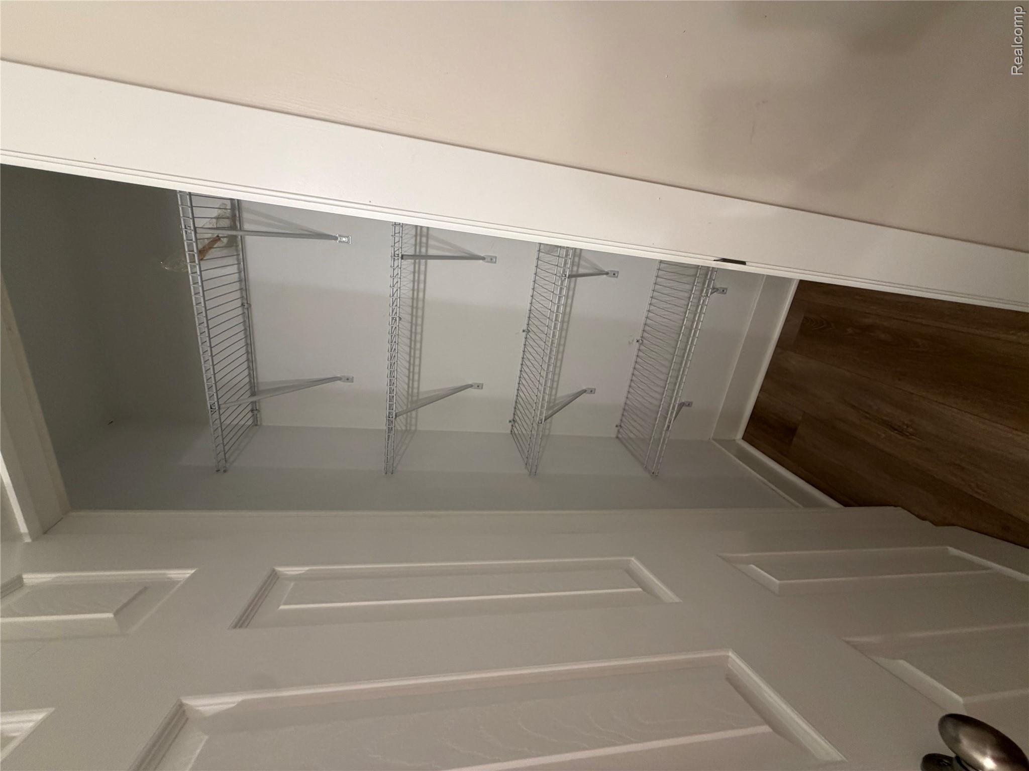 1246 House Road North Webberville, MI 48892 - Photo 7 of 22 Storage closet featuring multiple wire shelving units and wood-finish flooring