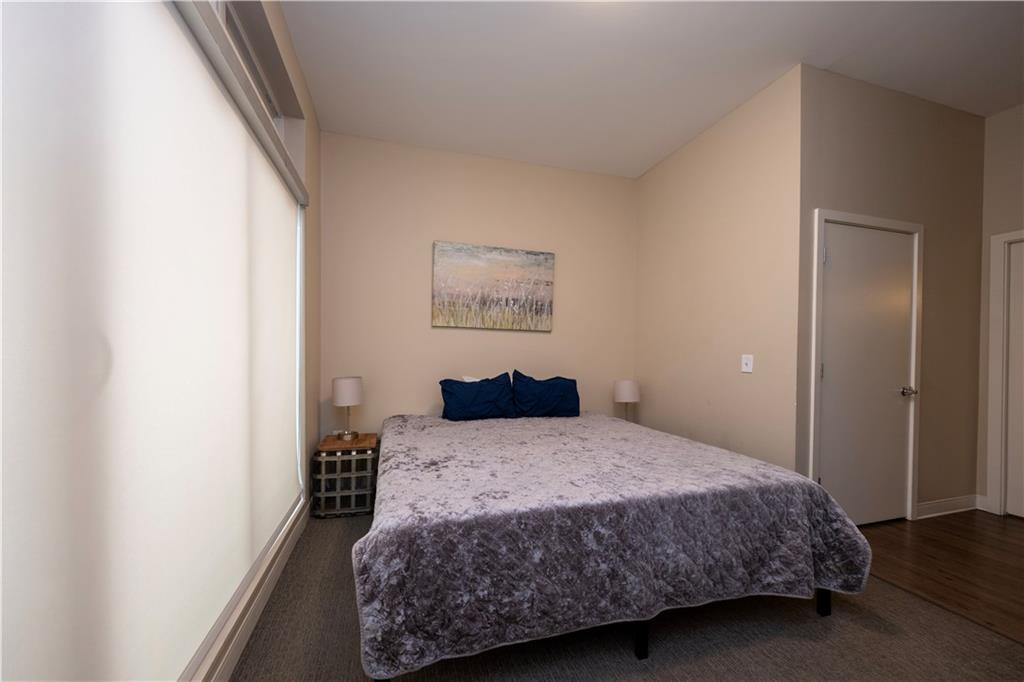 1655 Fifth Avenue, Unit 312 Pittsburgh, PA 15219 - Photo 21 of 29 a bedroom with a bed and painting on the wall