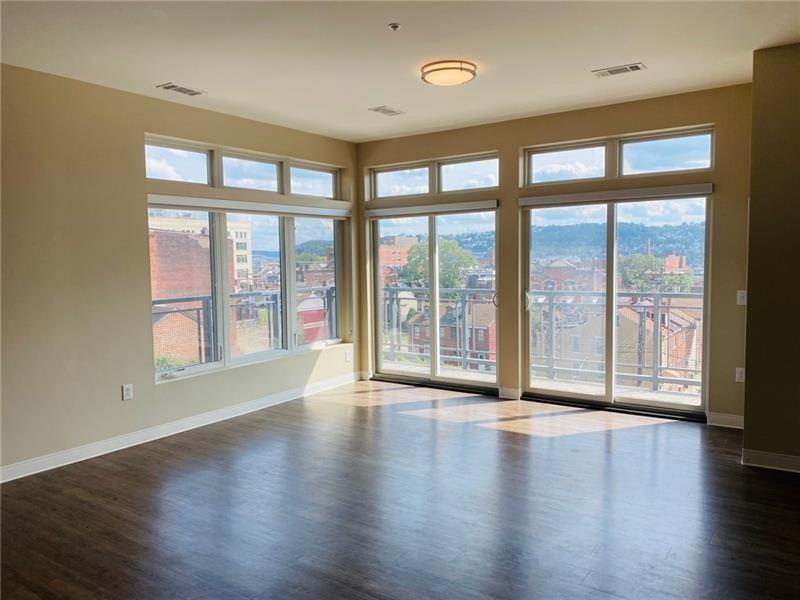 1655 Fifth Avenue, Unit 312 Pittsburgh, PA 15219 - Photo 23 of 29 a view of an empty room with wooden floor and a window