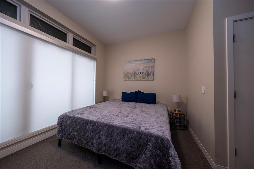 1655 Fifth Avenue, Unit 312 Pittsburgh, PA 15219 - Photo 28 of 29 a bedroom with a bed and painting on the wall