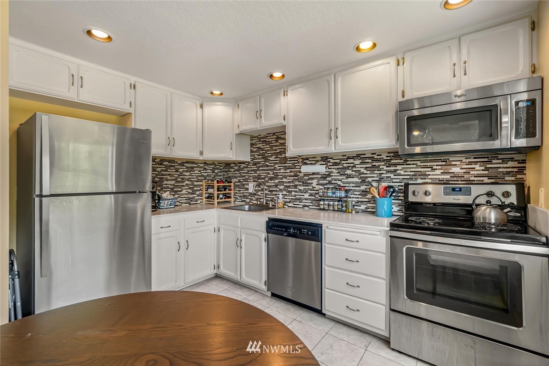 610 Aloha Street, Unit 302 Seattle, WA 98109 - Photo 11 of 27 a kitchen with stainless steel appliances granite countertop a stove a refrigerator and a granite counter tops