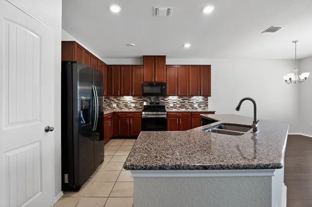 a kitchen with granite countertop stainless steel appliances and a sink