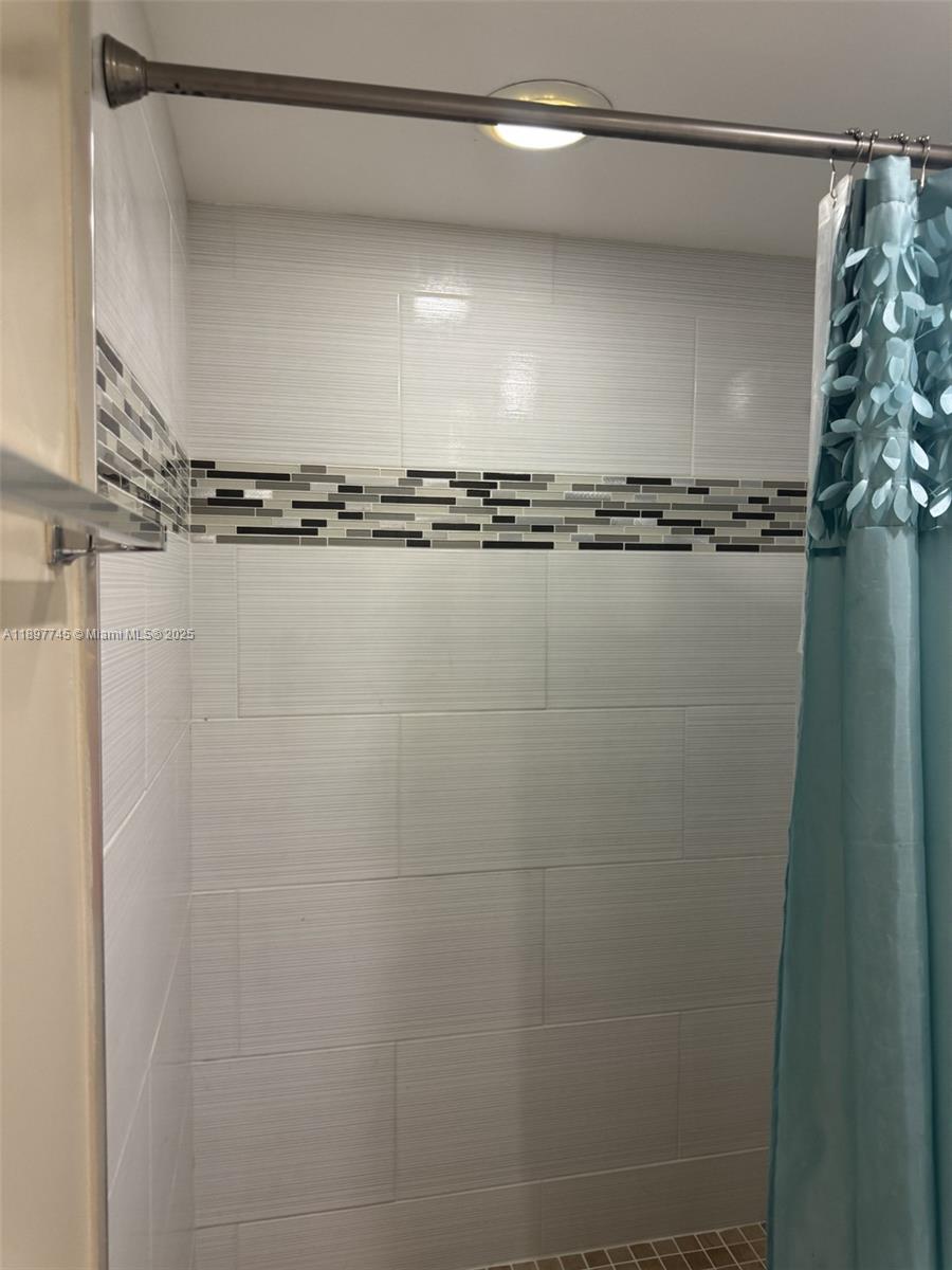 827 Northeast 199th Street, Unit 102 Miami, FL 33179 - Photo 1 of 6 a close view of a shower in a bathroom