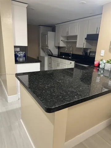 a kitchen with stainless steel appliances granite countertop a sink a stove and a microwave