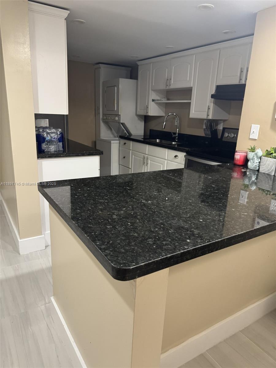 827 Northeast 199th Street, Unit 102 Miami, FL 33179 - Photo 4 of 6 a kitchen with stainless steel appliances granite countertop a sink a stove and a microwave