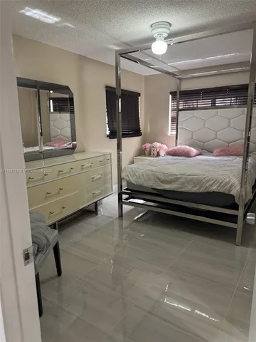 a bedroom with a bed and a flat tv screen on dresser
