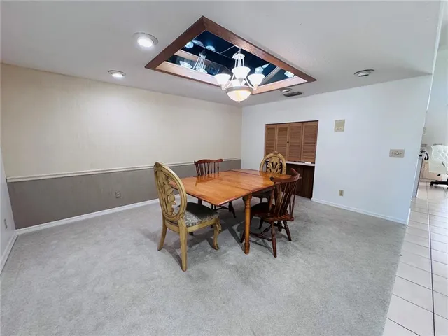 a view of a dining room with furniture and a chandelier fan