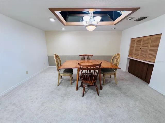 a view of a dining room with furniture and chandelier