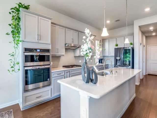 a kitchen with kitchen island a sink and a stove top oven