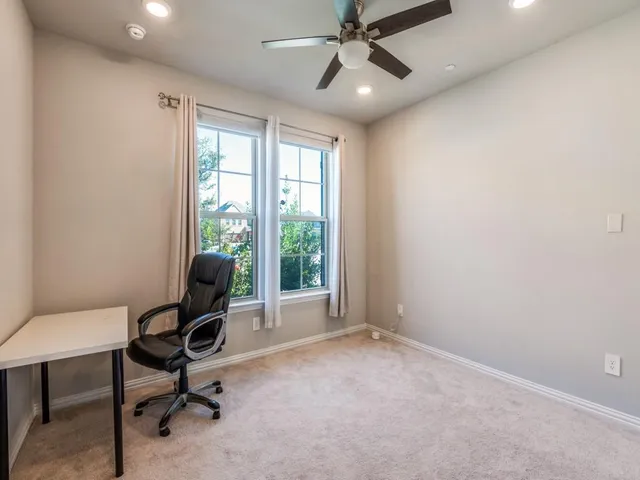 a view of a workspace with furniture and a window