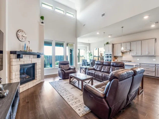 a living room with furniture a fireplace and a large window