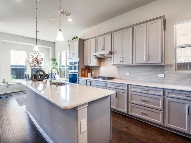 a large kitchen with kitchen island granite countertop a sink a center island and stainless steel appliances
