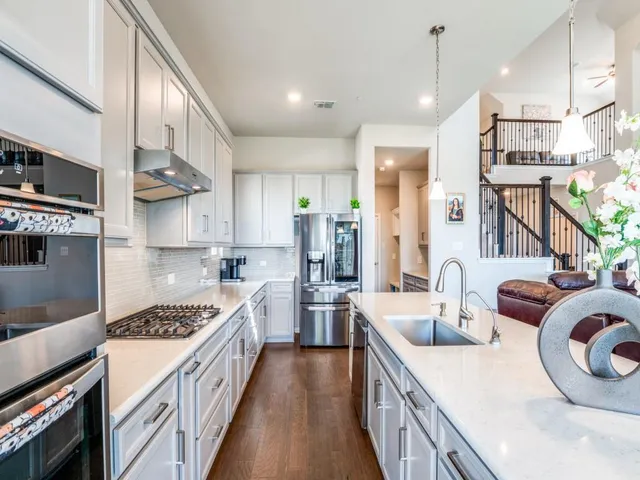 a kitchen with stainless steel appliances granite countertop a sink stove and refrigerator