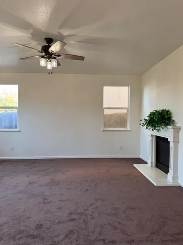 an empty room with windows and fireplace