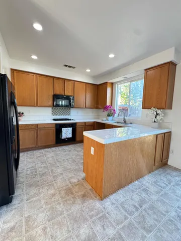 a kitchen with kitchen island a sink a counter top stainless steel appliances and cabinets