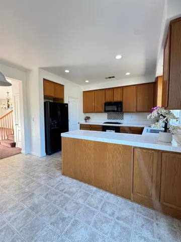 a kitchen with stainless steel appliances granite countertop a refrigerator and a stove top oven