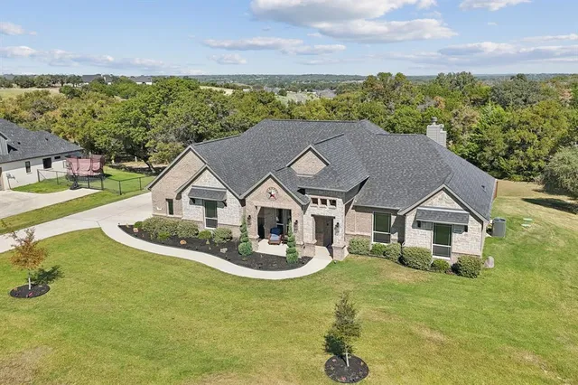an aerial view of a house with swimming pool garden and patio