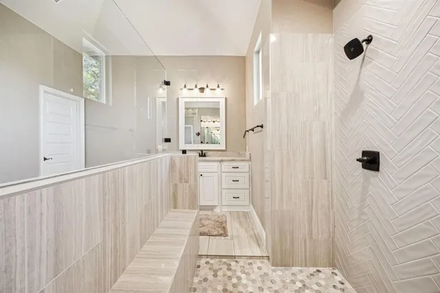 a bathroom with a tub sink and mirror