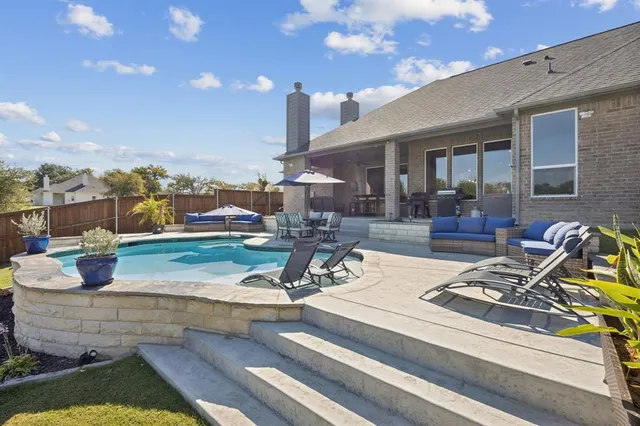 a view of a house with backyard water fountain and sitting area