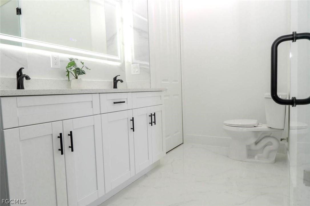 3206 14th Street Southwest Lehigh Acres, FL 33976 - Photo 25 of 38 a bathroom with a toilet sink and mirror